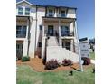 Attractive townhome with white brick, covered porch, and inviting staircase in a landscaped setting at 3564 Shore Wood Ave, Lawrenceville, GA 30044