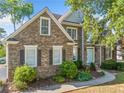 Charming brick home featuring a light blue front door, lush landscaping, and classic shutters at 4295 Cami Way, Buford, GA 30519