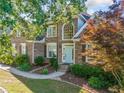 Charming brick home with mature trees, manicured lawn, and inviting light blue front door at 4295 Cami Way, Buford, GA 30519