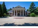 Grand home with brick facade, prominent white columns, and a circular driveway creates a stately and impressive entrance at 4790 Shallowford Rd, Roswell, GA 30075