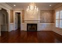Traditional living room with hardwood floors, a fireplace, decorative wallpaper, and a chandelier at 4790 Shallowford Rd, Roswell, GA 30075