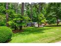 Landscaped front yard featuring mature trees and meticulously maintained lawn at 6505 Whispering Ln, Atlanta, GA 30328