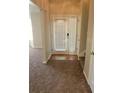 View of the entryway with carpeted floor and glass front door with sidelights at 1752 Spring Hill Cv, Lithonia, GA 30058