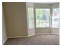 Open-concept living room features large windows and plush carpeting at 1752 Spring Hill Cv, Lithonia, GA 30058