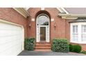 Inviting front entrance showcasing brickwork, an arched window, and decorative exterior lighting fixtures at 2324 Littlebrooke Ln, Dunwoody, GA 30338