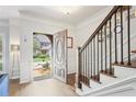 Bright, airy foyer with hardwood floors, white wainscoting, and a staircase with black wrought iron railing at 2567 Briers North Dr, Dunwoody, GA 30360