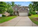 Charming two-story brick home featuring a well-manicured lawn and a two-car garage at 4650 Pleasant Woods Dr, Cumming, GA 30028