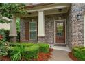 Inviting front porch with brick facade, decorative shutters, and well-maintained landscaping at 4650 Pleasant Woods Dr, Cumming, GA 30028