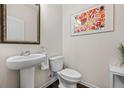 Stylish half bathroom with a pedestal sink and a modern mirror at 118 Woodhouse Cir, Acworth, GA 30102