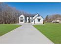 Beautiful two-story modern farmhouse with a long driveway, black trim, and pristine green lawn at 1604 Greendale Rd, Covington, GA 30014