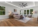 Bright main bedroom featuring wood floors, a tray ceiling, and views of the outdoors at 1604 Greendale Rd, Covington, GA 30014