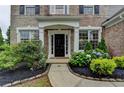 Inviting front entrance with decorative landscaping and a classic black front door at 450 Hilingdon Way, Suwanee, GA 30024