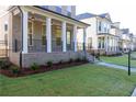 Beautifully landscaped front yard with lush green grass and a covered porch enhance the home's exterior at 157 Basil St, Cumming, GA 30040