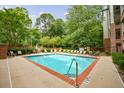 Community pool surrounded by lounge chairs and lush greenery for relaxation at 50 Biscayne Dr # 2106, Atlanta, GA 30309