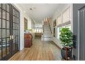 Welcoming foyer featuring hardwood floors, paneled walls, with stairs to the second level and french doors to living room at 940 Longley Nw Ave, Atlanta, GA 30318