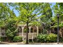 Charming home with a covered front porch, decorative railings, lush trees, and a welcoming walkway at 980 Faith Se Ave, Atlanta, GA 30316