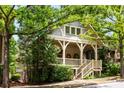 Charming home with a covered front porch, decorative railings, lush trees, and an inviting walkway at 980 Faith Se Ave, Atlanta, GA 30316