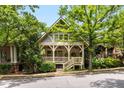 Charming home with a covered front porch, decorative railings, lush trees, and beautiful architectural details at 980 Faith Se Ave, Atlanta, GA 30316