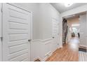 Bright hallway with hardwood floors, white trim, and multiple doors leading to different areas of the house at 5525 Sable Way, Atlanta, GA 30349