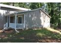 Side view of home showcasing neutral siding, covered porch, and neatly landscaped yard at 5561 Petite Pt, Lithonia, GA 30058