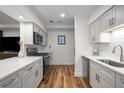 Well-lit kitchen features modern stainless steel appliances, white cabinets, and wood floors at 6980 Roswell Rd # B13, Sandy Springs, GA 30328