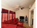 Comfortable living room with a large red sectional sofa and a ceiling fan for added comfort at 3505 Saddle Creek Ln, Ellenwood, GA 30294