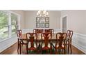Formal dining room featuring a large wooden table, stylish chairs, and natural light from a window at 997 Thousand Oaks Nw Bnd, Kennesaw, GA 30152