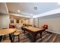 Spacious basement with a pool table, seating, and unique flooring, perfect for entertaining and relaxing at 3589 Tamerton Trce, Buford, GA 30519