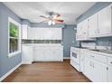 Well-lit kitchen with white cabinets, modern appliances, and a stylish backsplash at 4614 Ridge Dr, Pine Lake, GA 30072
