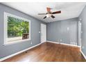 Bright living room featuring hardwood floors, a ceiling fan, and a large window for natural light at 4614 Ridge Dr, Pine Lake, GA 30072