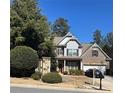 Well-maintained home with a brick and siding exterior, complemented by mature trees and landscaping at 121 Royal Sunset Dr, Dallas, GA 30157