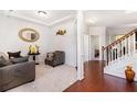 Bright foyer featuring hardwood floors, a staircase with wooden banister, and neutral-toned walls with decorative accents at 121 Royal Sunset Dr, Dallas, GA 30157