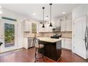 Well-lit kitchen featuring dark wood floors, granite countertops, stainless steel appliances, and an island with seating at 121 Royal Sunset Dr, Dallas, GA 30157