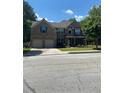 Charming two-story brick home featuring an attached two-car garage, covered porch and well-manicured lawn at 200 Birchwood Dr, Loganville, GA 30052