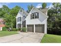 Charming two-story stucco home boasting an attached two-car garage and front yard with mature trees at 1097 Soaring Way, Marietta, GA 30062
