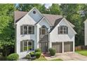Charming two-story stucco home featuring a manicured lawn, shrubbery, and a two-car garage at 1097 Soaring Way, Marietta, GA 30062