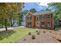 Charming two-story brick home with an attached two-car garage and traditional landscaping at 4999 Willow Creek Dr, Woodstock, GA 30188