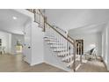 Bright entry foyer with a staircase featuring white banisters and stained handrail plus light wood-look floors at 4999 Willow Creek Dr, Woodstock, GA 30188