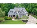 Beautiful two-story home with lush green lawn, mature trees, and an elegant exterior design at 2101 Hunters Green Dr, Lawrenceville, GA 30043