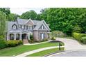 Attractive home featuring a well-maintained lawn, curved walkway, and stone and brick accents at 2101 Hunters Green Dr, Lawrenceville, GA 30043