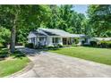 Lovely one-story home featuring a well-manicured lawn and long driveway, set against a backdrop of mature trees at 290 Dania Dr, Alpharetta, GA 30009