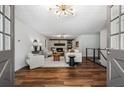 Living room with wood floors, neutral furniture, fireplace, and a unique light fixture at 290 Dania Dr, Alpharetta, GA 30009