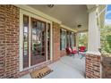 Inviting brick front porch featuring a welcome mat, comfortable seating, and classic architectural details at 910 Ovalene Sw Ln, Marietta, GA 30064