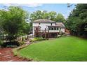 Expansive backyard with lush lawn, mature landscaping, stone pathway and deck with screened-in porch at 3323 Lancing Ct, Duluth, GA 30096