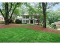 Stately white brick home with a lush green lawn and a mature tree providing shade and curb appeal at 3323 Lancing Ct, Duluth, GA 30096