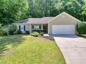 Lovely single-story home featuring green lawn, complemented by mature trees at 5600 Walnut Creek Nw Ct, Lilburn, GA 30047