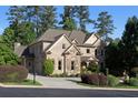 Charming two-story home with stone and brick, showcasing lush landscaping and an attached garage at 8805 Marion Dr, Duluth, GA 30097