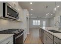 Modern kitchen featuring stainless steel appliances, quartz countertops, and a kitchen island at 3348 Cranston Ln, Kennesaw, GA 30144