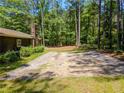 Gravel parking pad with mature trees offering a versatile space on this wooded lot at 5216 Wheeler Dr, Loganville, GA 30052