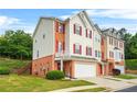 Attractive townhouse with two-car garage, neutral siding, brick accents and a lush, well-manicured lawn at 5989 Turfway Park Ct, Sugar Hill, GA 30518